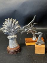 Three car accessory mascots: a wheatsheaf, Pegasus and a circa 1930 Raleigh Safety Seven, each