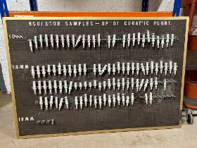 A peg board display of spark plug ceramic insulators.