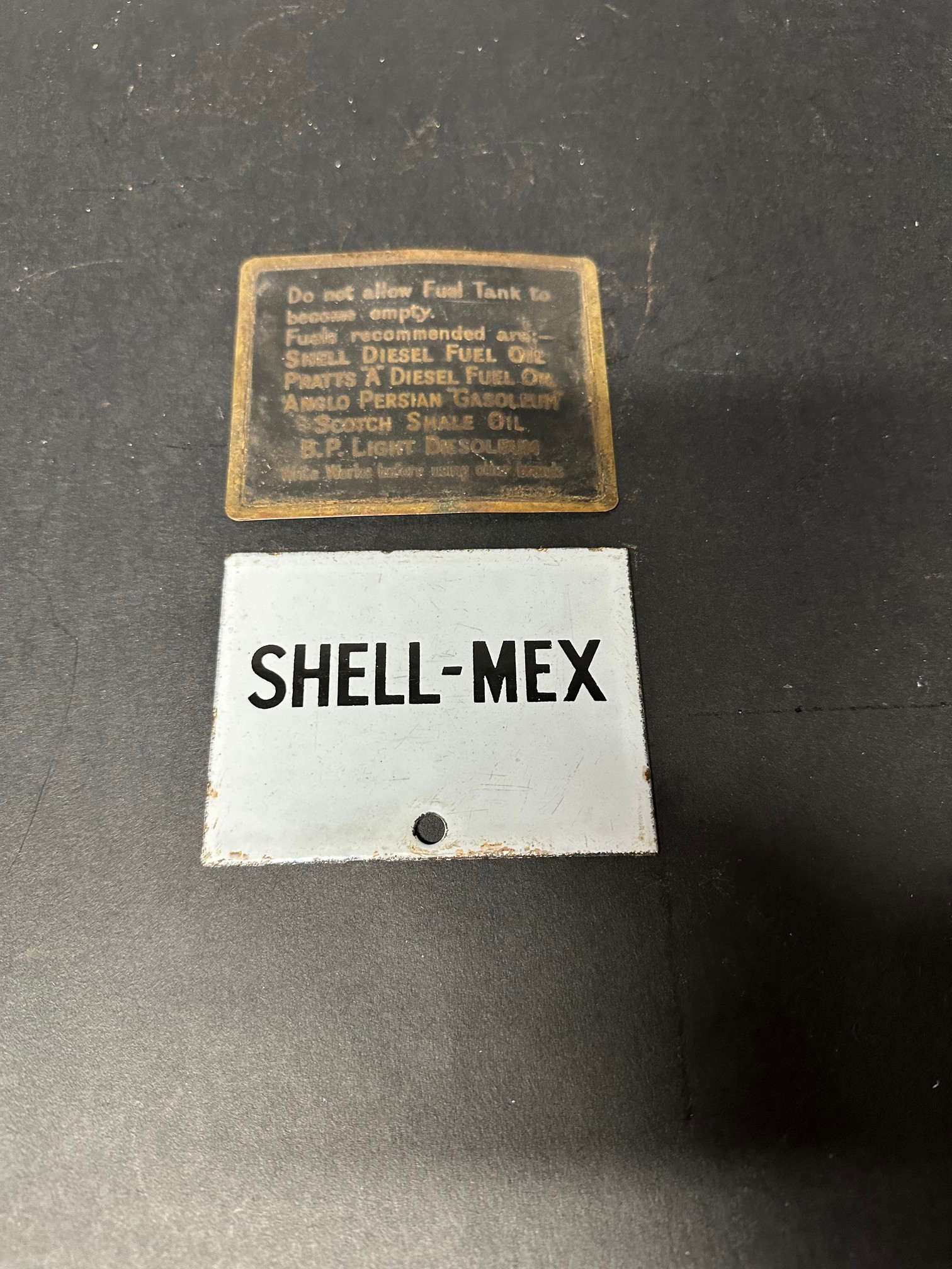 A Shell-Mex enamel plaque and brass petrol tank plate recommending Shell, Pratts, BP etc.