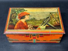 A tin moneybox depicting a lady at the wheel with coastal scenery advertising Pette Wormerveer