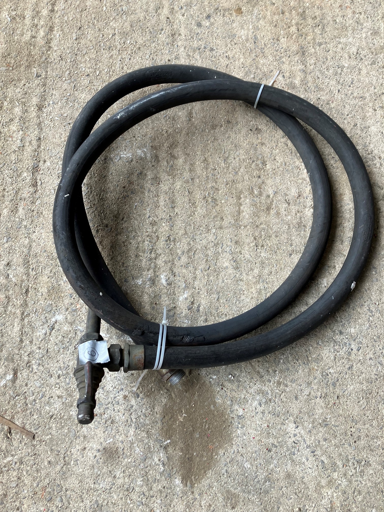 A petrol pump hose with brass T-shape nozzle.