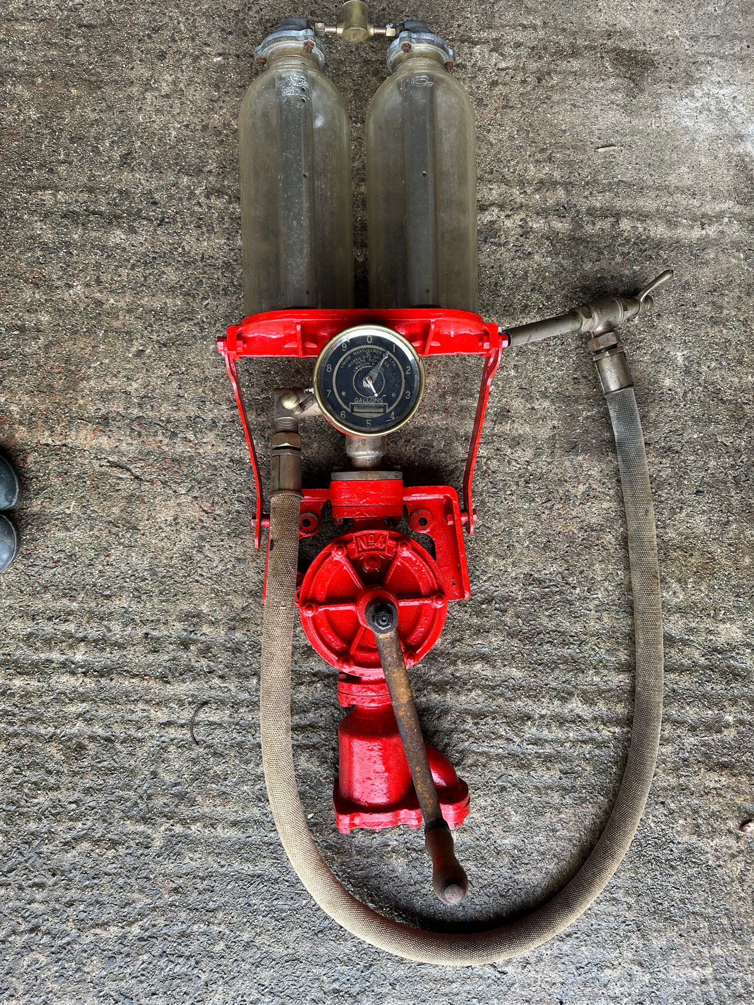 A Hammond one gallon hand pump fitted with two 1 x gallon glass cylinders, a canvas hose and nozzle.