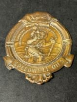 A St. Christopher dashboard plaque (patron saint for safe travel) advertising Speedwell Oils.