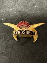 An Aeroshell badge with crescent shaped pin to verso.