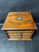 A sewing reel cabinet with Gutterman's Sewing Silk branding, 11 1/4" tall, 15" wide and 15 1/4"
