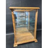 A glass tabletop display case with three adjustable glass shelves and mirrored back, 17 1/4" wide