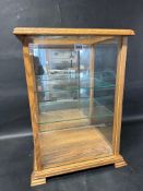 A glass tabletop display case with three adjustable glass shelves and mirrored back, 17 1/4" wide