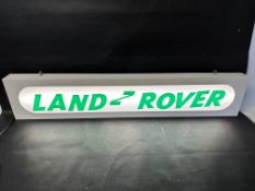 A hanging lighbox with Land Rover applied in acrylic letters, 47 1/4 x 9 x 2 3/4".