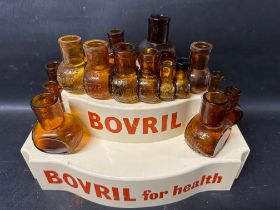 A two tier plastic Bovril shop display stand with associated glass bottles.