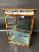 A Boisseller's Chocolate (of Watford) cabinet with glass shelves and milk glass etched panels to