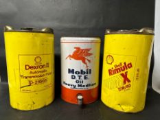 Three five-gallon oil drums: Mobil D.T.E. Heavy Medium, Shell Rimula X 15W/40 and Shell Dexron II.