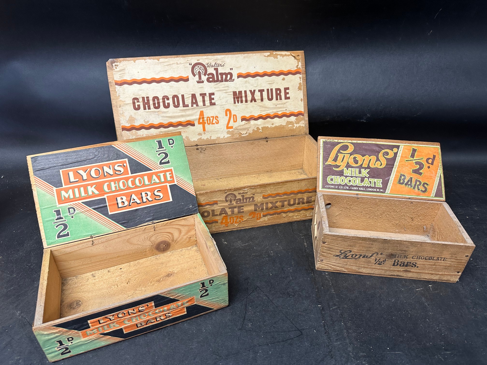 Three wooden counter top chocolate dispensing boxes: two for Lyons' Milk Chocolate Bars and the
