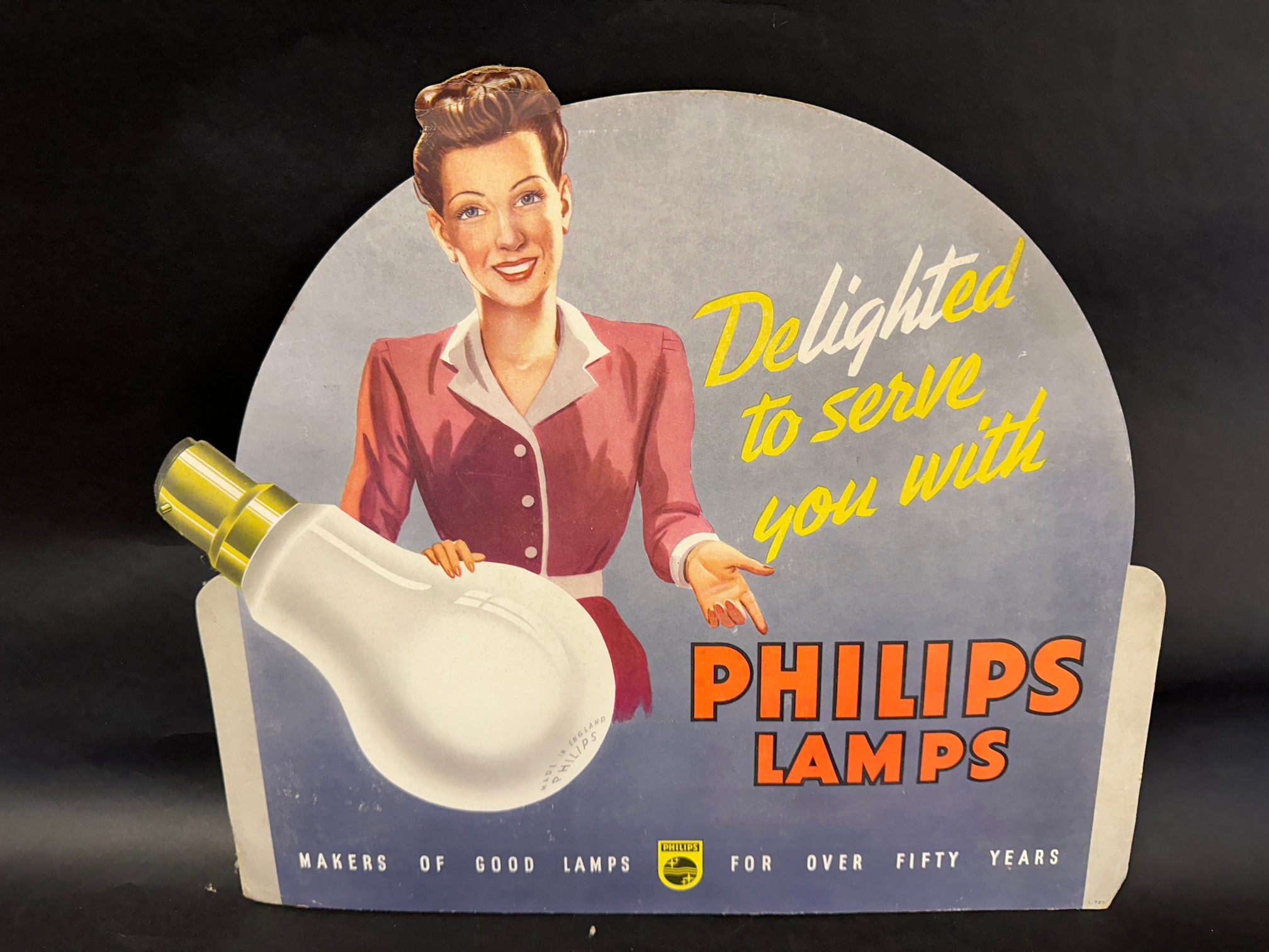 A Phillips Lamps pictorial diecut showcard depicting a lady 'delighted to serve you', 21 x 18 1/2".