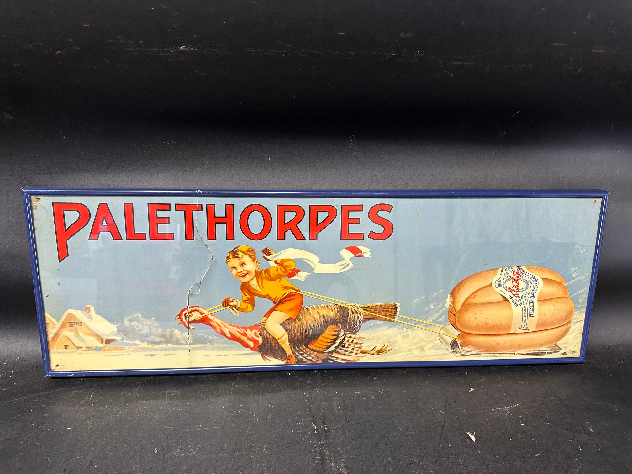 A Palethorpes Sausages advertisement depicting a snow scene of a boy riding a turkey pulling a