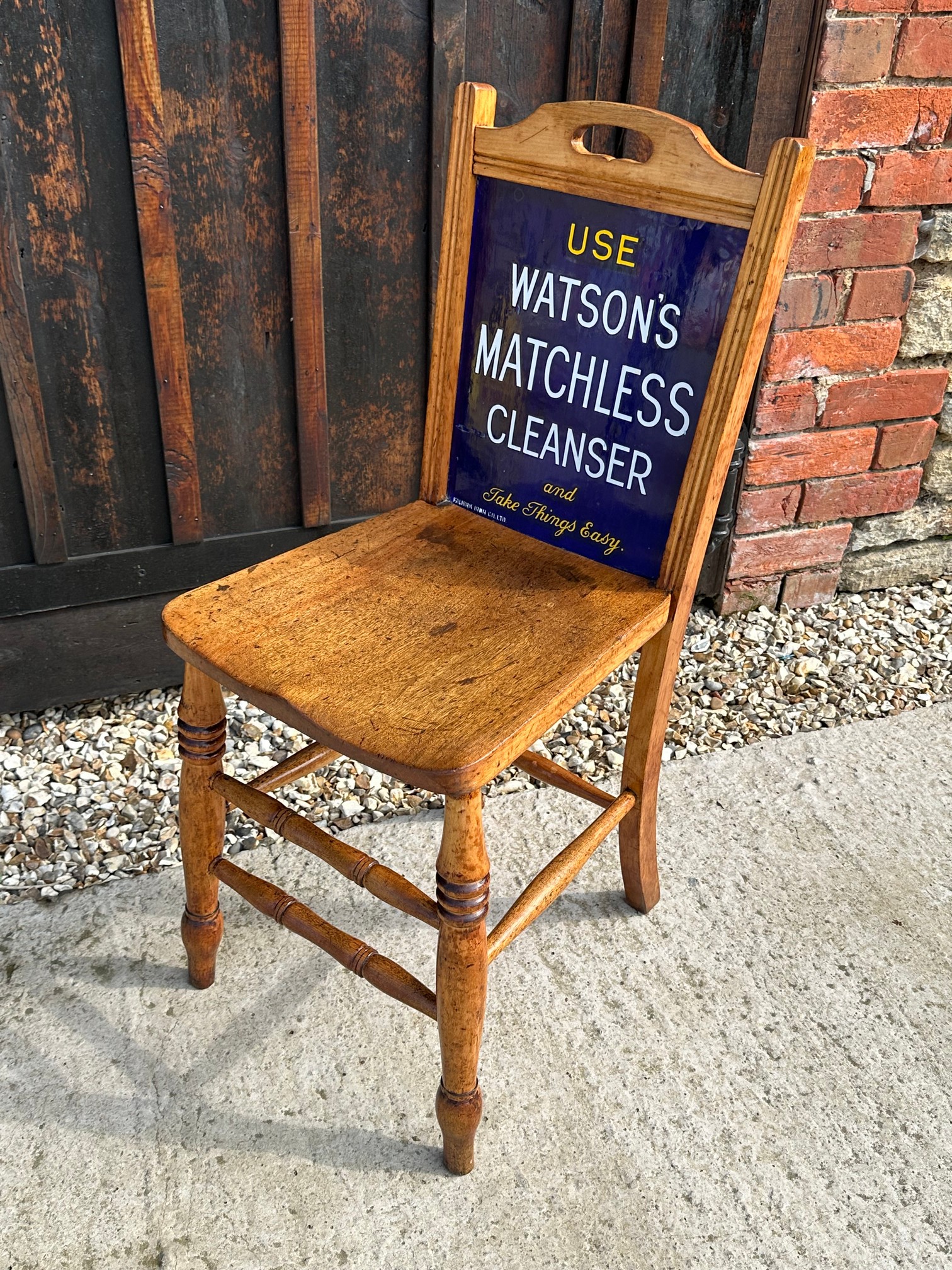 An enamel backed chair advertising Watson's Matchless Cleanser to front and Sparkla Soap to rear, by