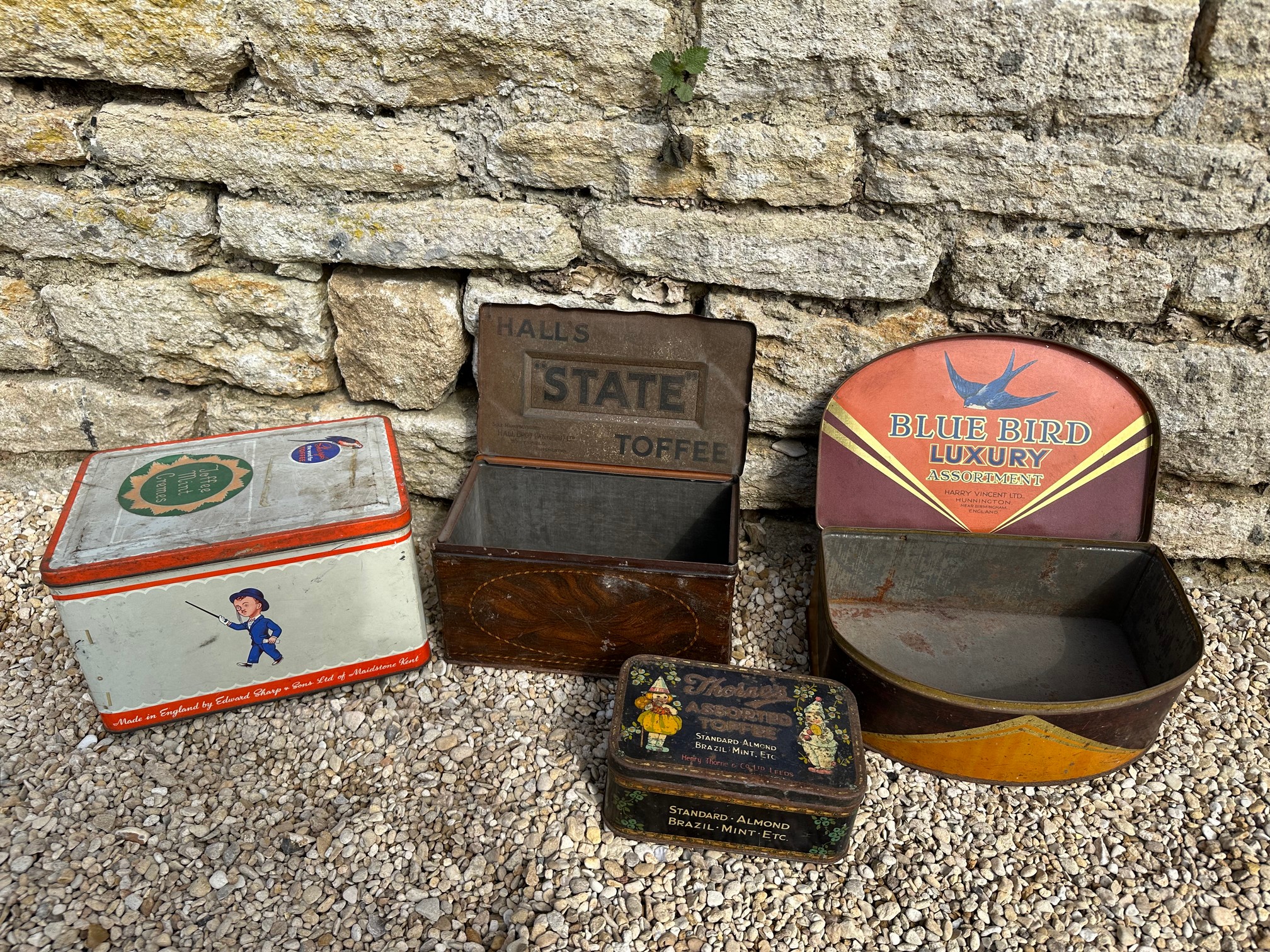 Four toffee tins: Blue Bird, Hall's "State" Toffee, Thorne's Assorted Toffee and Sharp's.