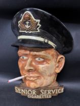 A Senior Service Cigarettes wall mounted plaster advertising plaque with glass 'cat's eyes', 10 1/