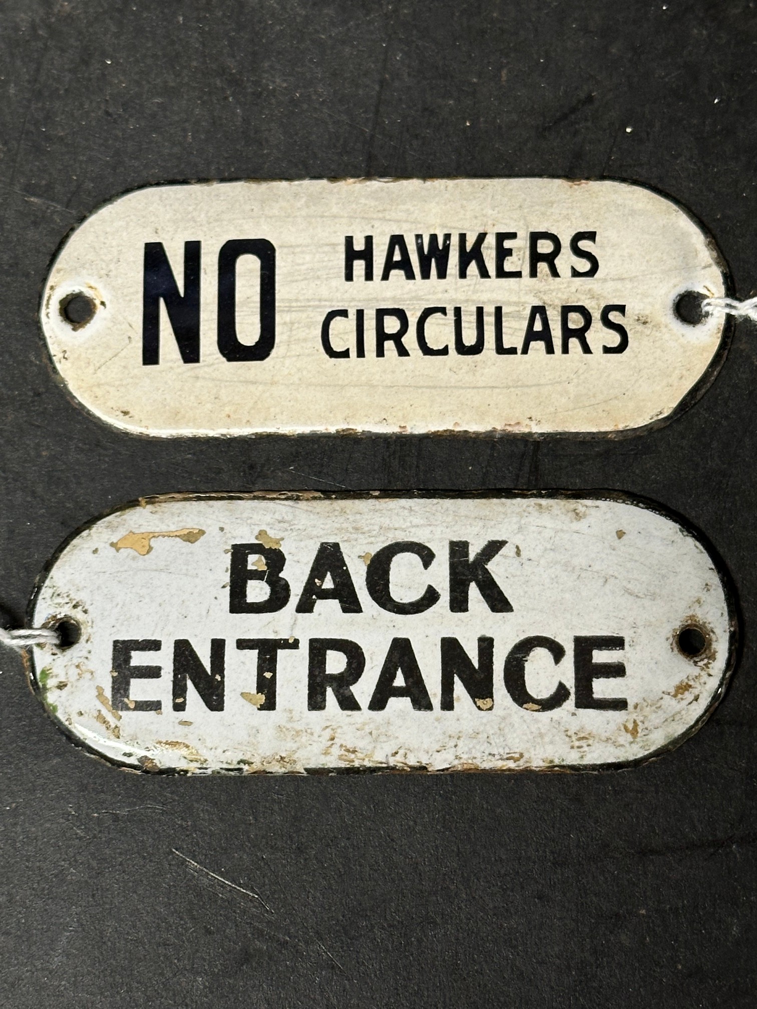 Two enamel door plaques: Back Entrance, 4 x 1 3/4" and NO Hawkers Circulars, 4 x 1 1/2".