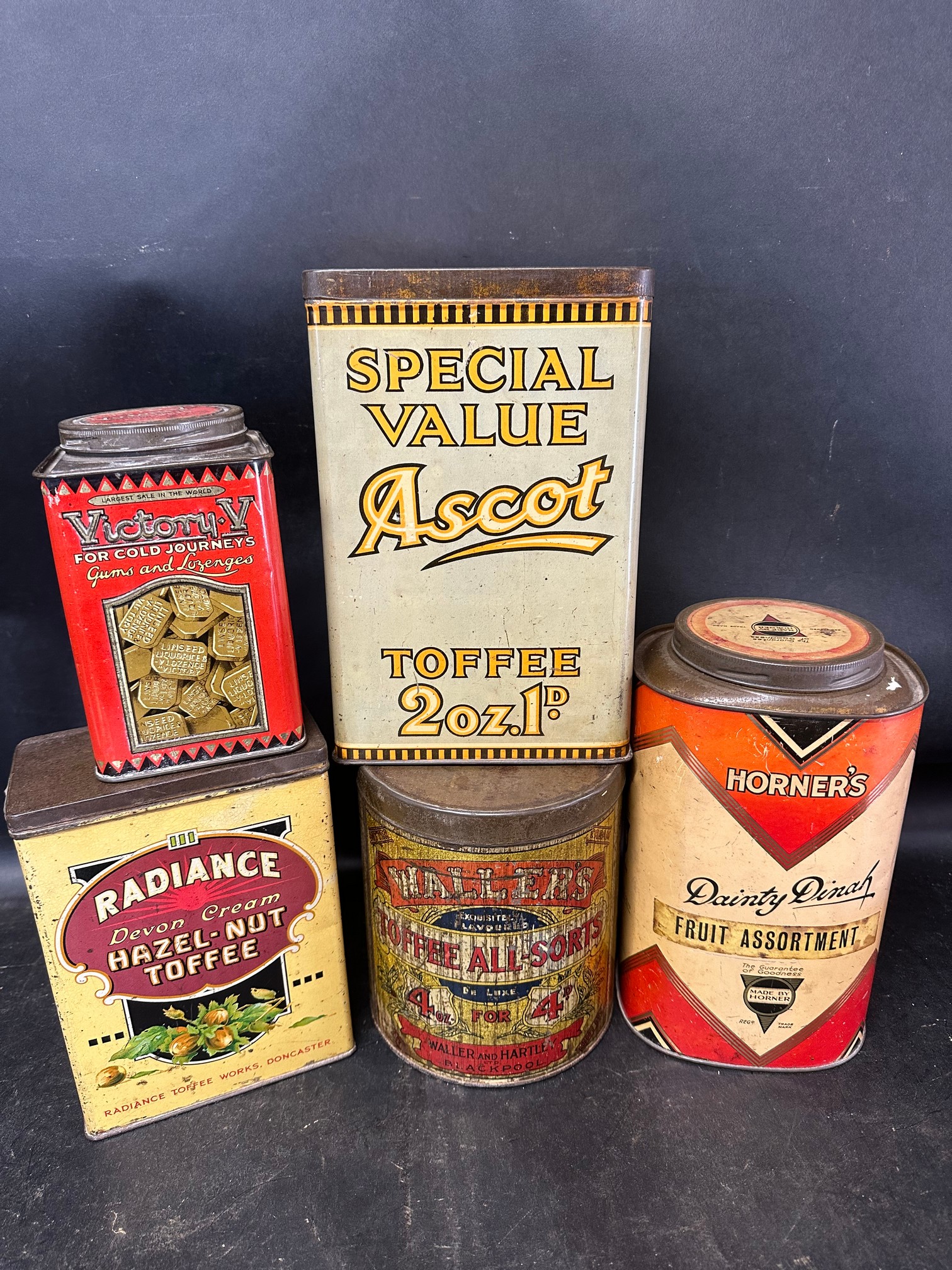 Five confectionery tins: Radiance Hazel-Nut Toffee 7 3/4" tall, Waller's Toffee All-Sorts, Ascot