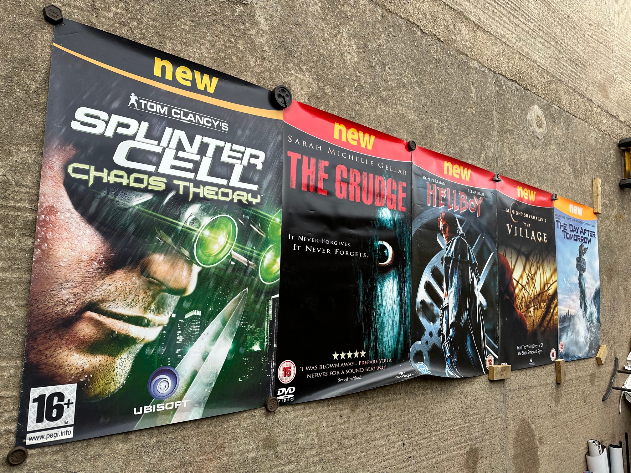 Five film posters: Tom Clancy's Splinter Cell, 2005; The Grudge, 2004; Hellboy, 2004; The Village,