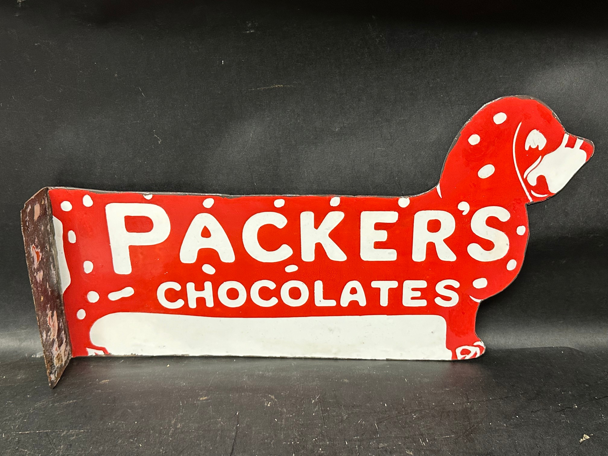 A Packer's Chocolates die cut double sided enamel advertising sign in the form of a dog, with