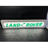 A hanging lightbox with Land Rover applied in acrylic letters, 47 1/4 x 9 x 2 3/4".