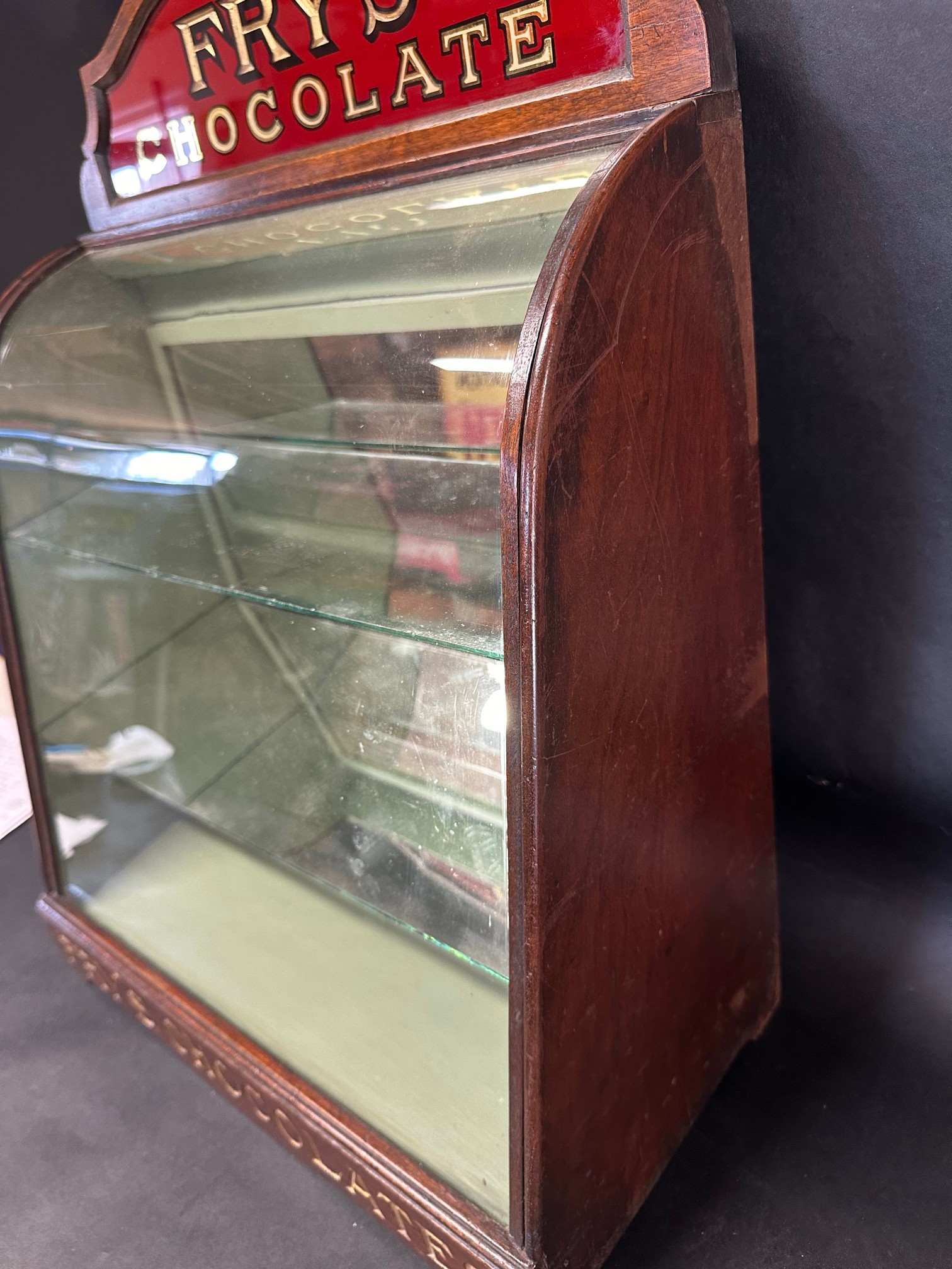 A Fry's Chocolates bowed glass cabinet with pediment, 25 1/2" tall x 9 1/2" deep x 17 3/4" wide. - Image 6 of 7