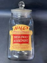 A glass counter top sweetie jar labelled Hall's Broadway Assortment, 13" tall.