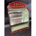 A Fry's Chocolates bowed glass cabinet with pediment, 25 1/2" tall x 9 1/2" deep x 17 3/4" wide.