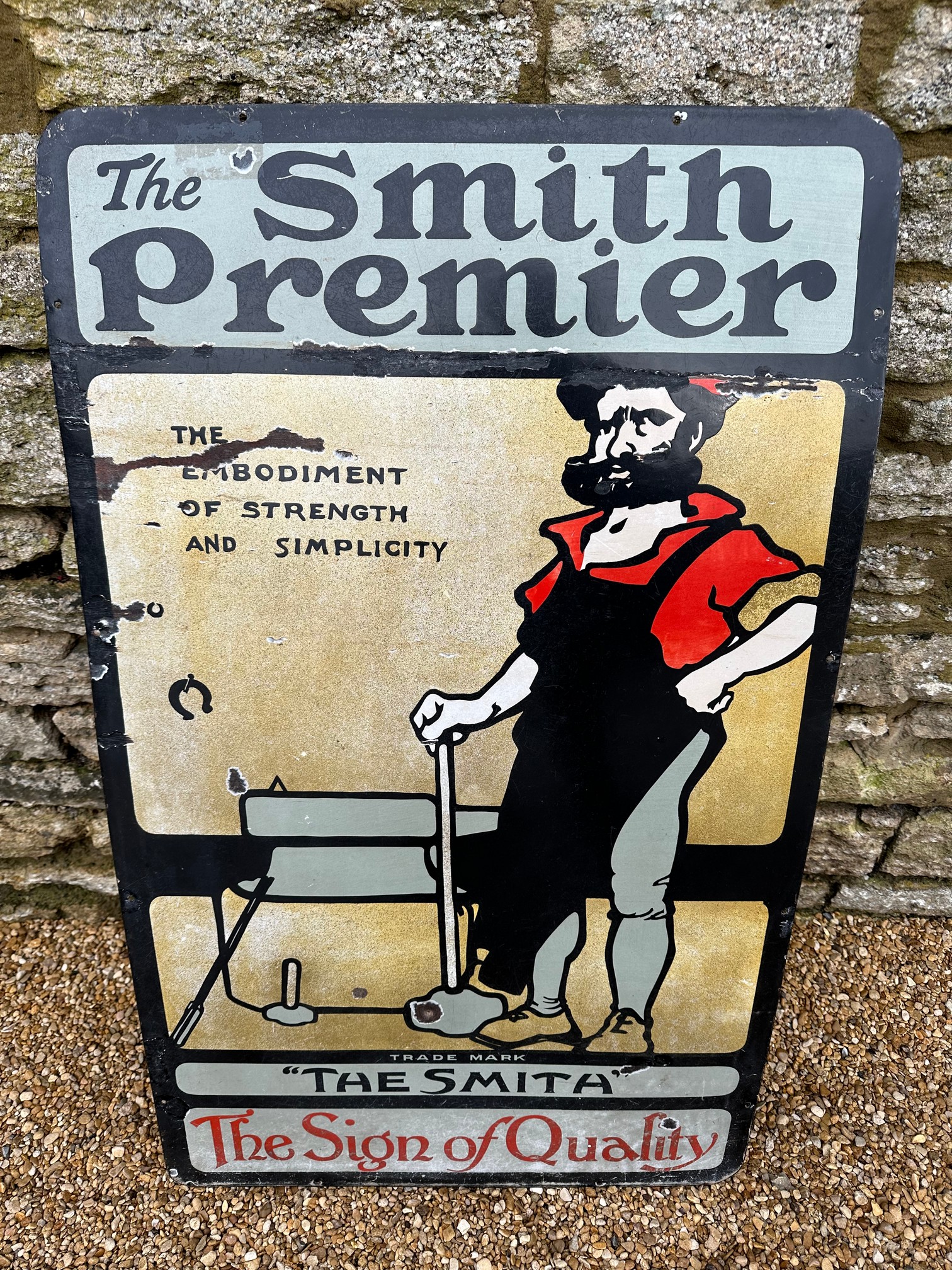 A rare and early The Smith Premier pictorial enamel advertising sign depicting a blacksmith (for