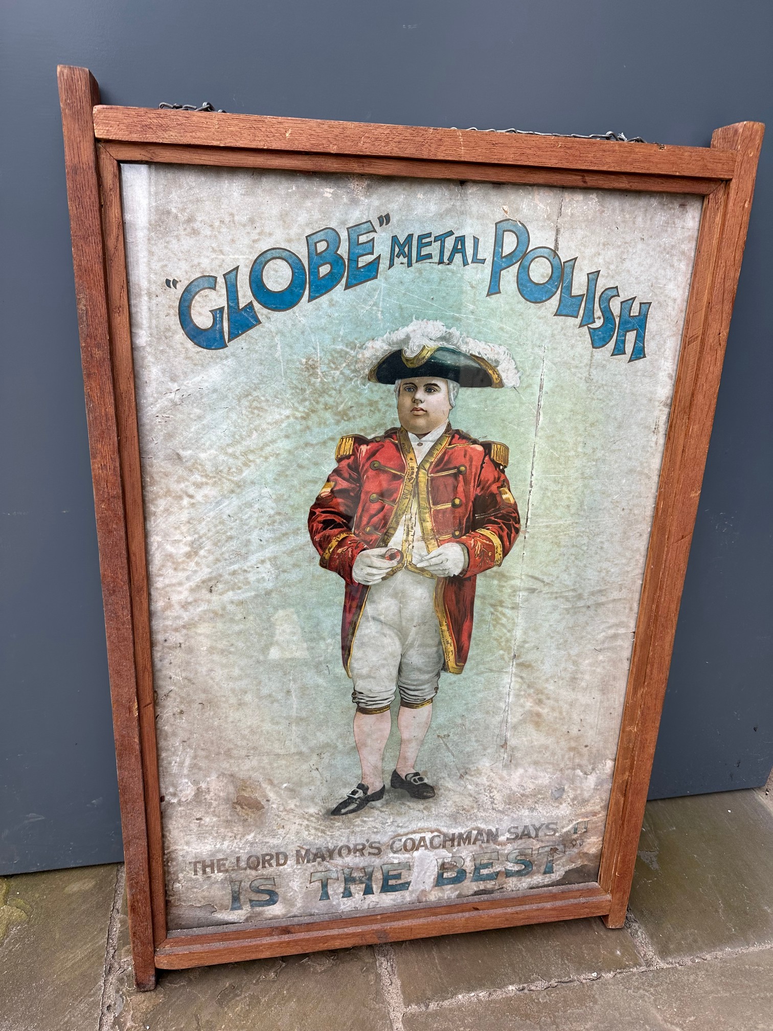 A large hanging wooden frame containing advertising for Globe Metal Polish to each side