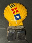 An American license plate topper in the form of a shell displaying three nautical flags representing