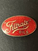 A Filtrate Oils enamel badge with moon crest attachment to reverse.