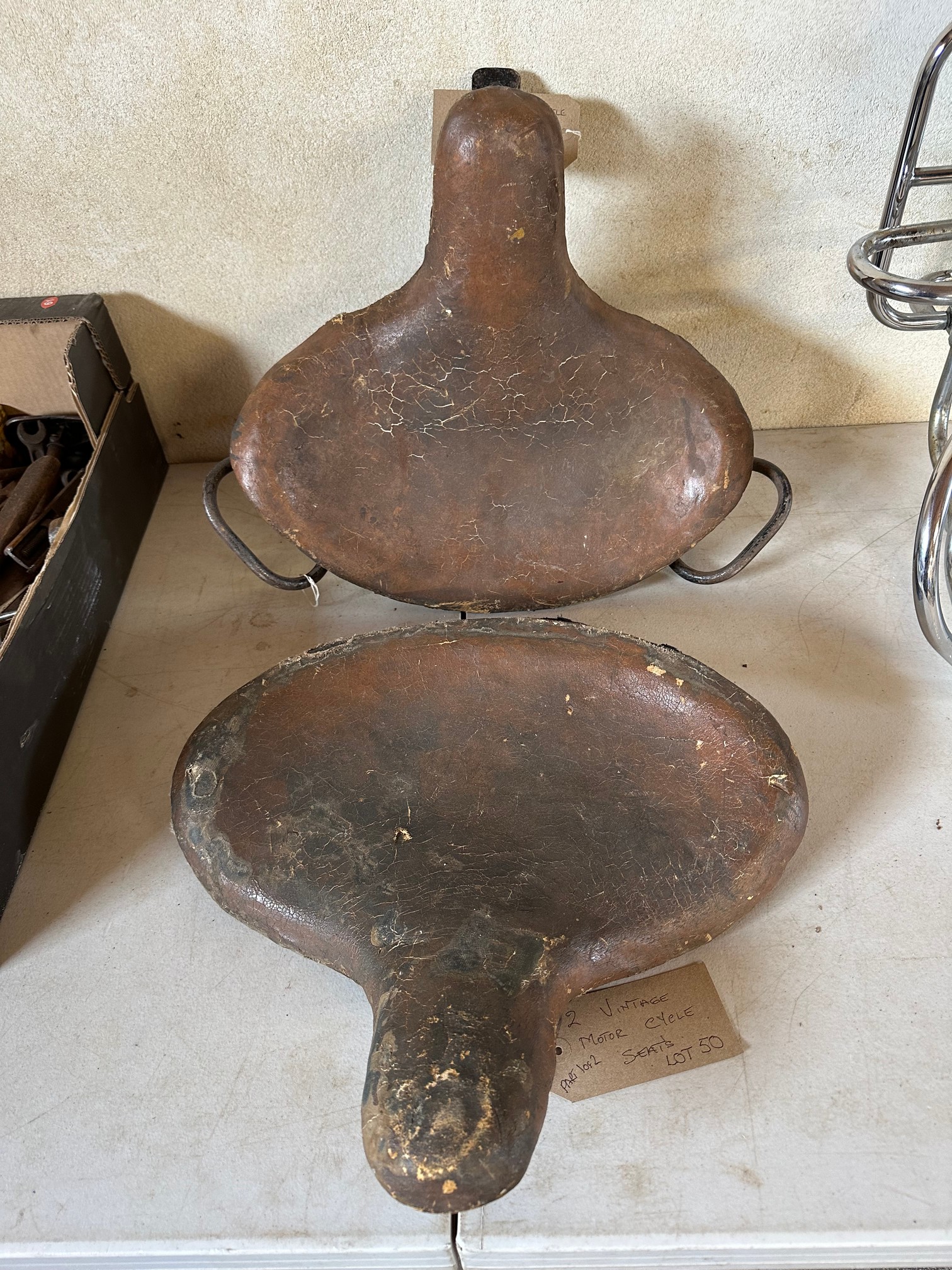 Two large vintage motorcycle saddles.