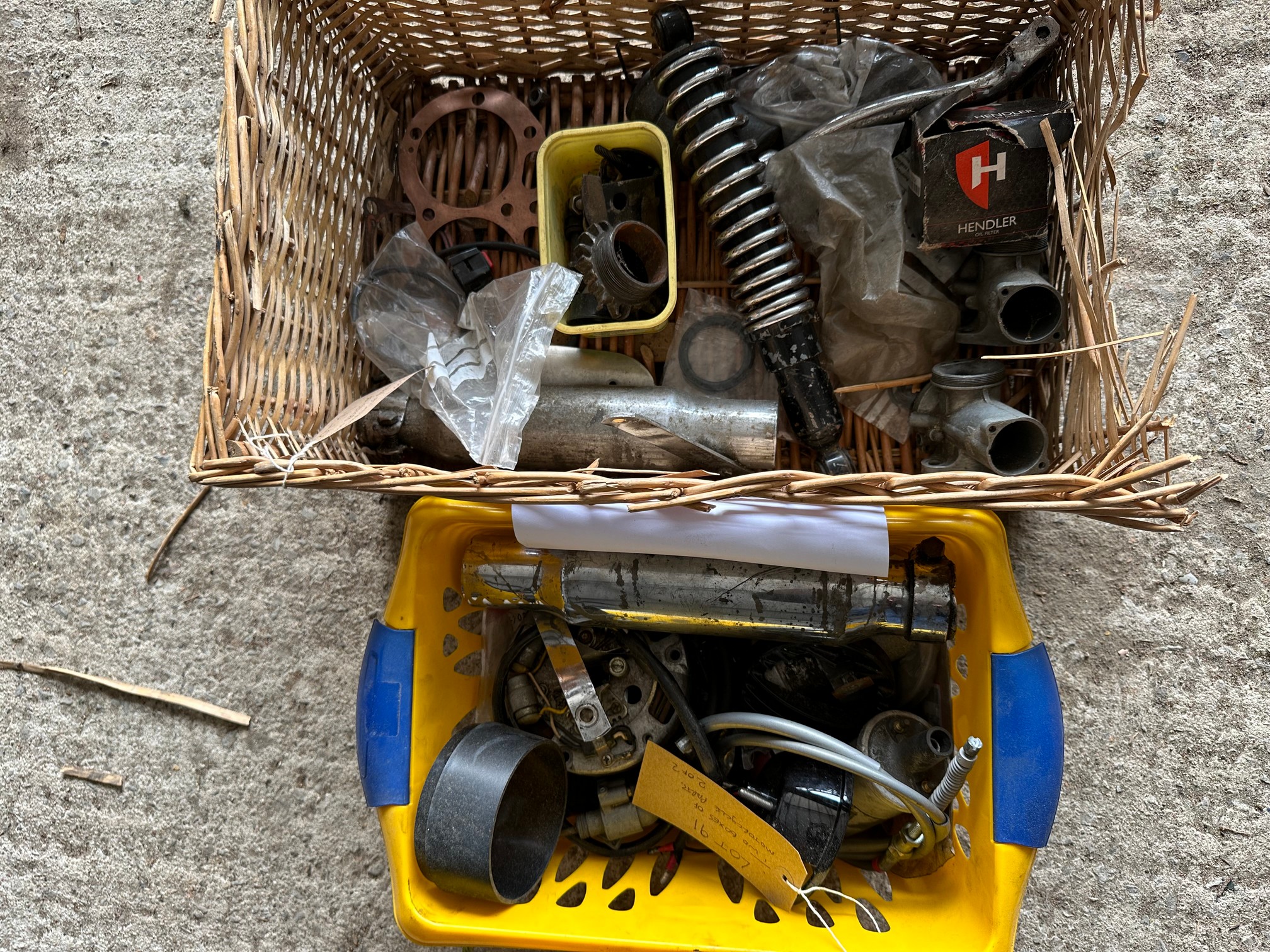Two boxes of various motorcycle parts.