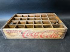 A Coca-Cola 24 bottle wooden crate with metal support to corners and handles to each end, 18 x 11