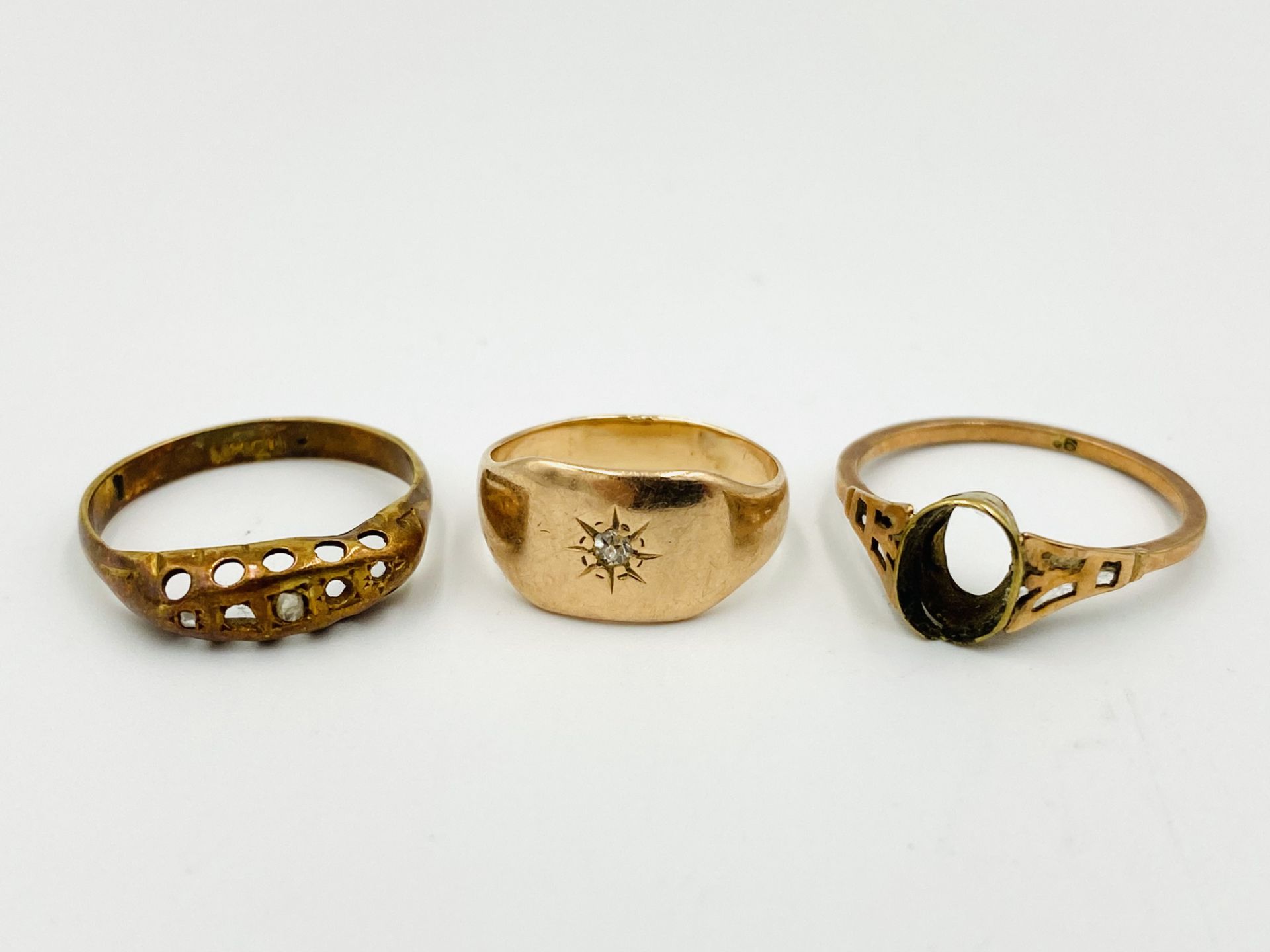 Two gold rings together with a yellow metal ring