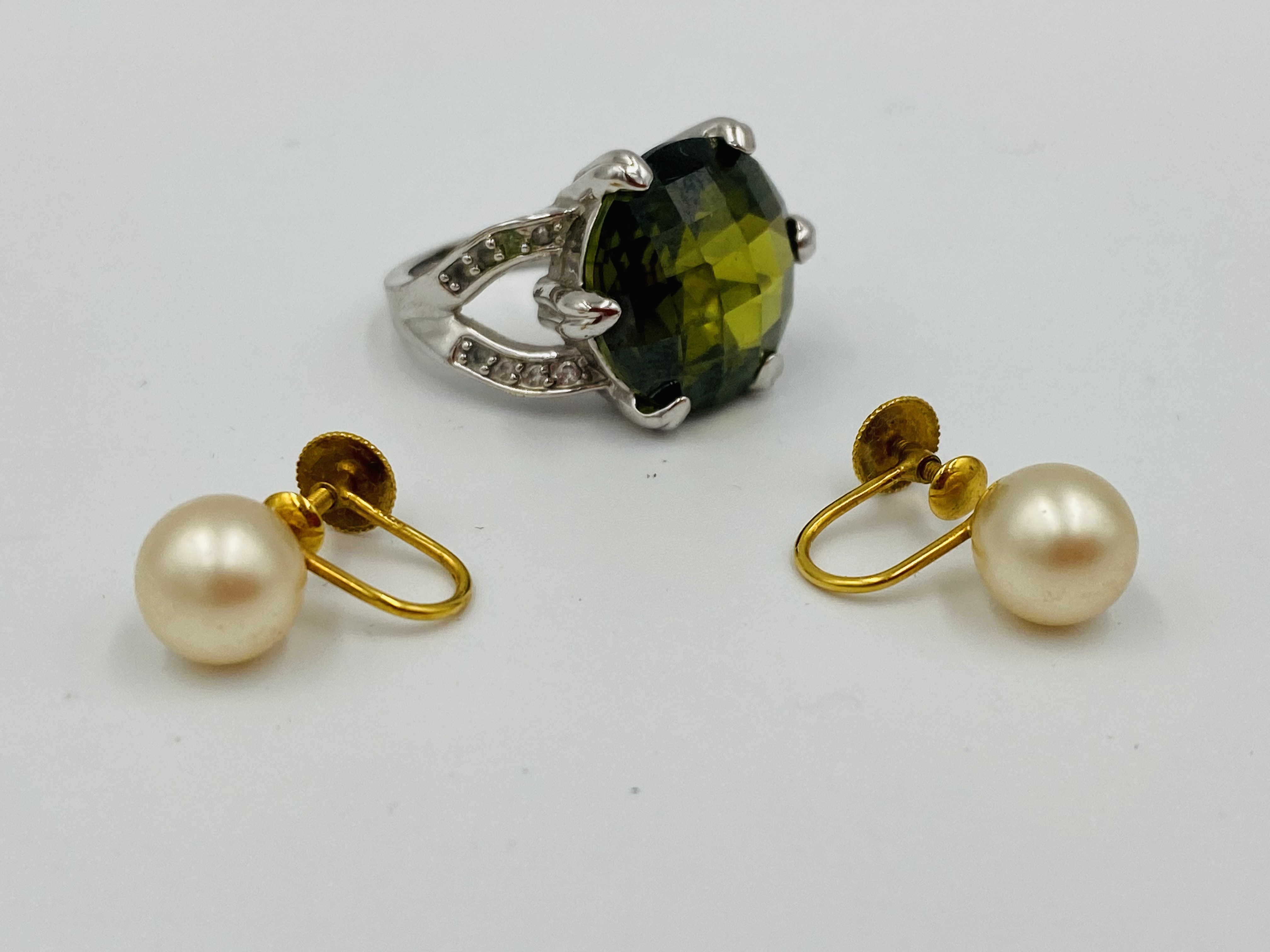 Pair of Ciro earrings together with a ring set with a tourmaline