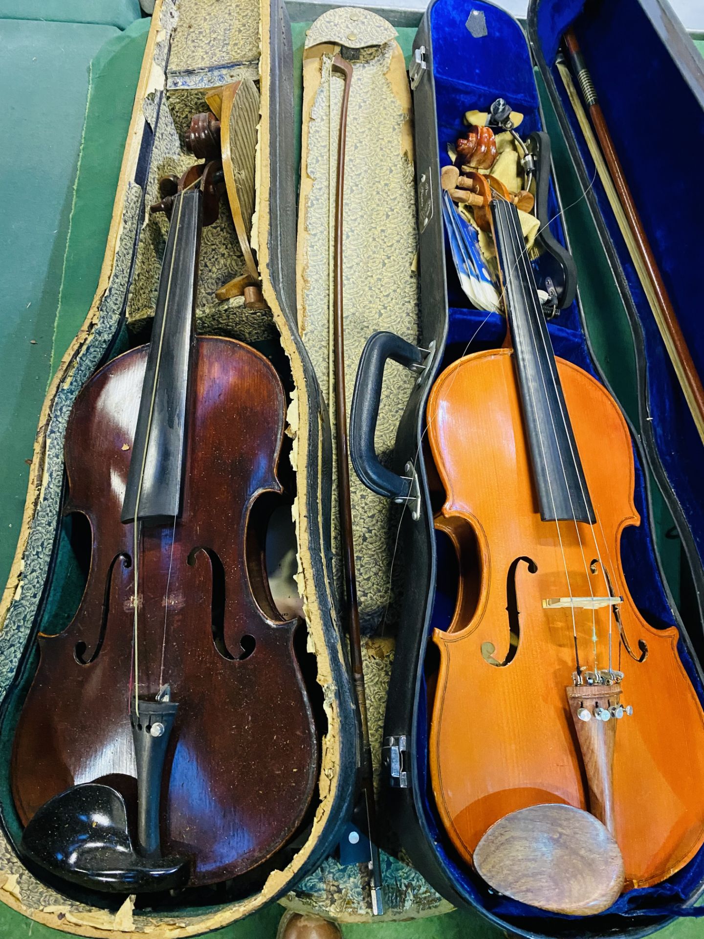 Three boxed violins with bows.