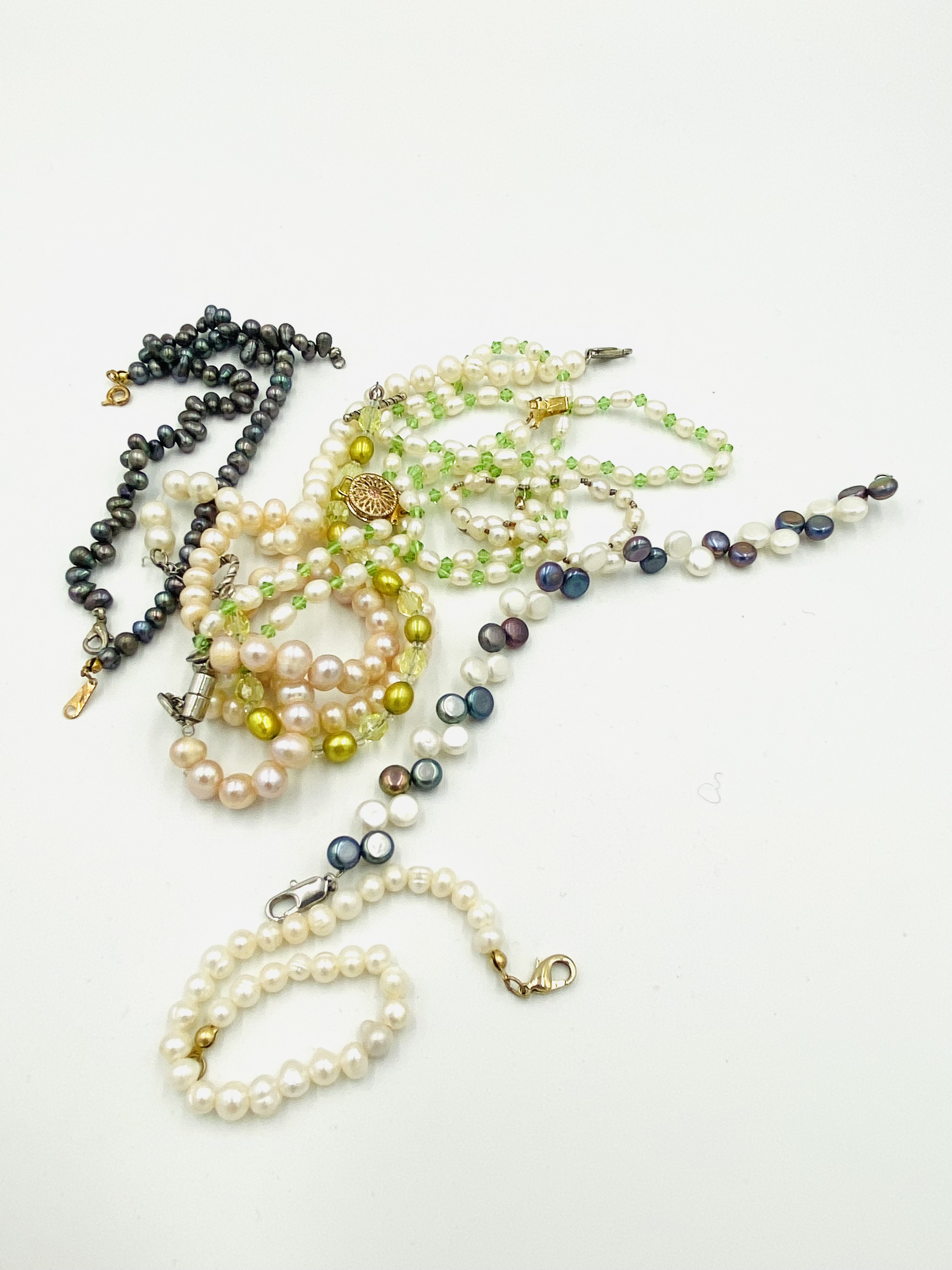 Ten pearl bracelets.