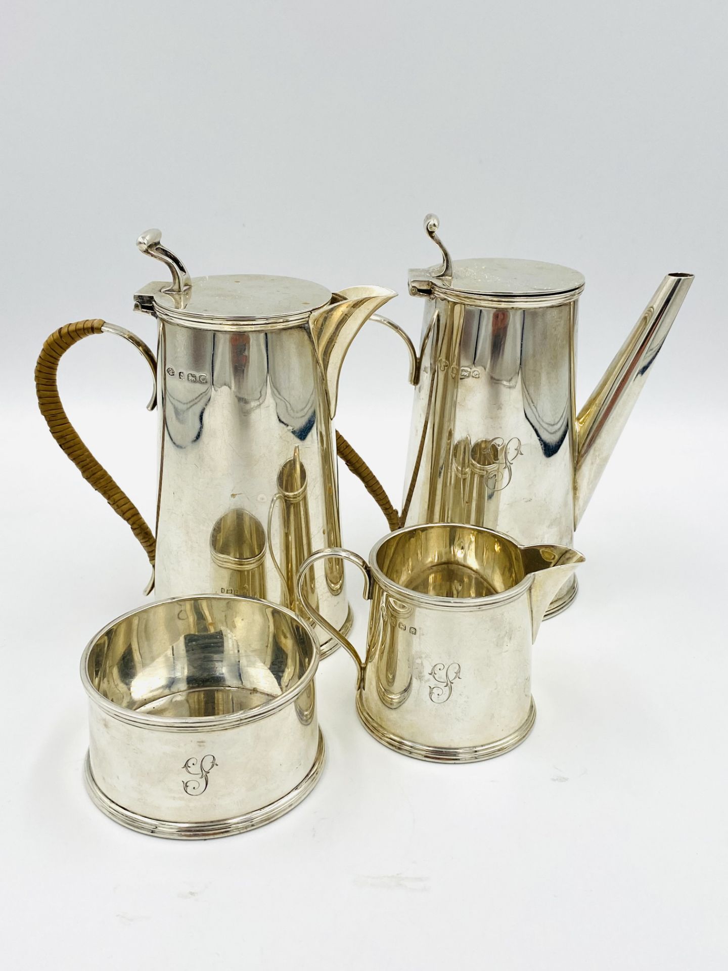 Three piece silver coffee set, retailed by Harrods; together with a silver hot water jug to match