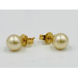 Pair of 18ct gold earrings set with a pearl