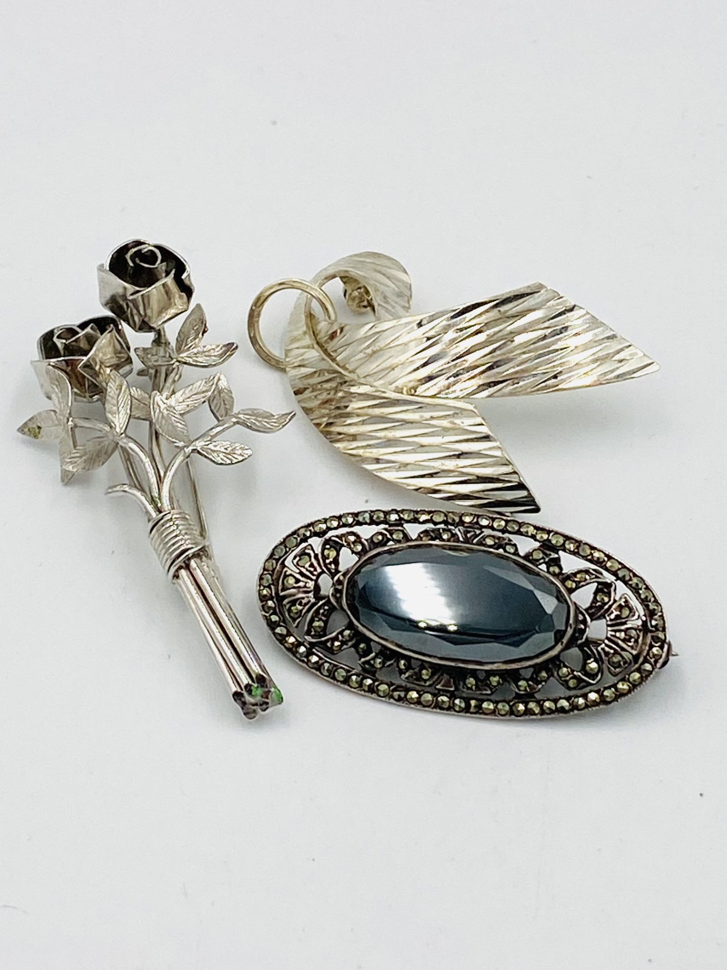 Three silver brooches