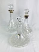 Two cut glass decanters with silver collars together with a cut glass ships decanter