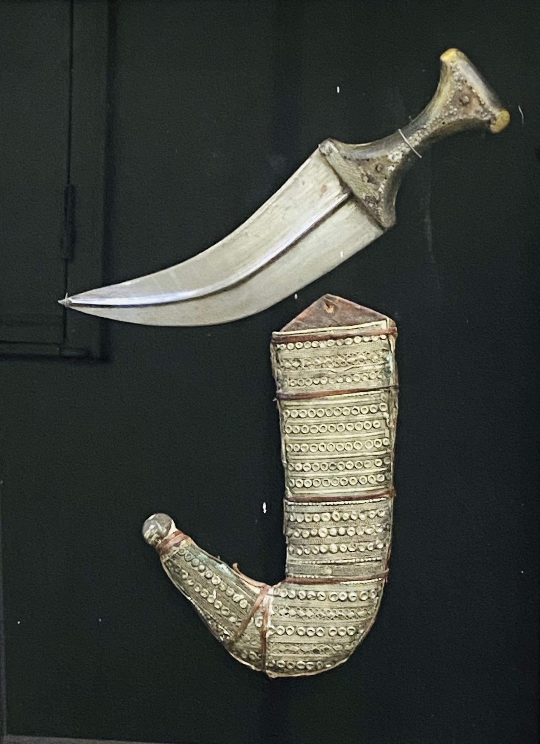 Framed and glazed Middle Eastern white metal dagger