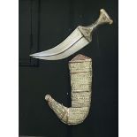 Framed and glazed Middle Eastern white metal dagger