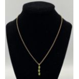 9ct gold chain with yellow metal and green stone pendant