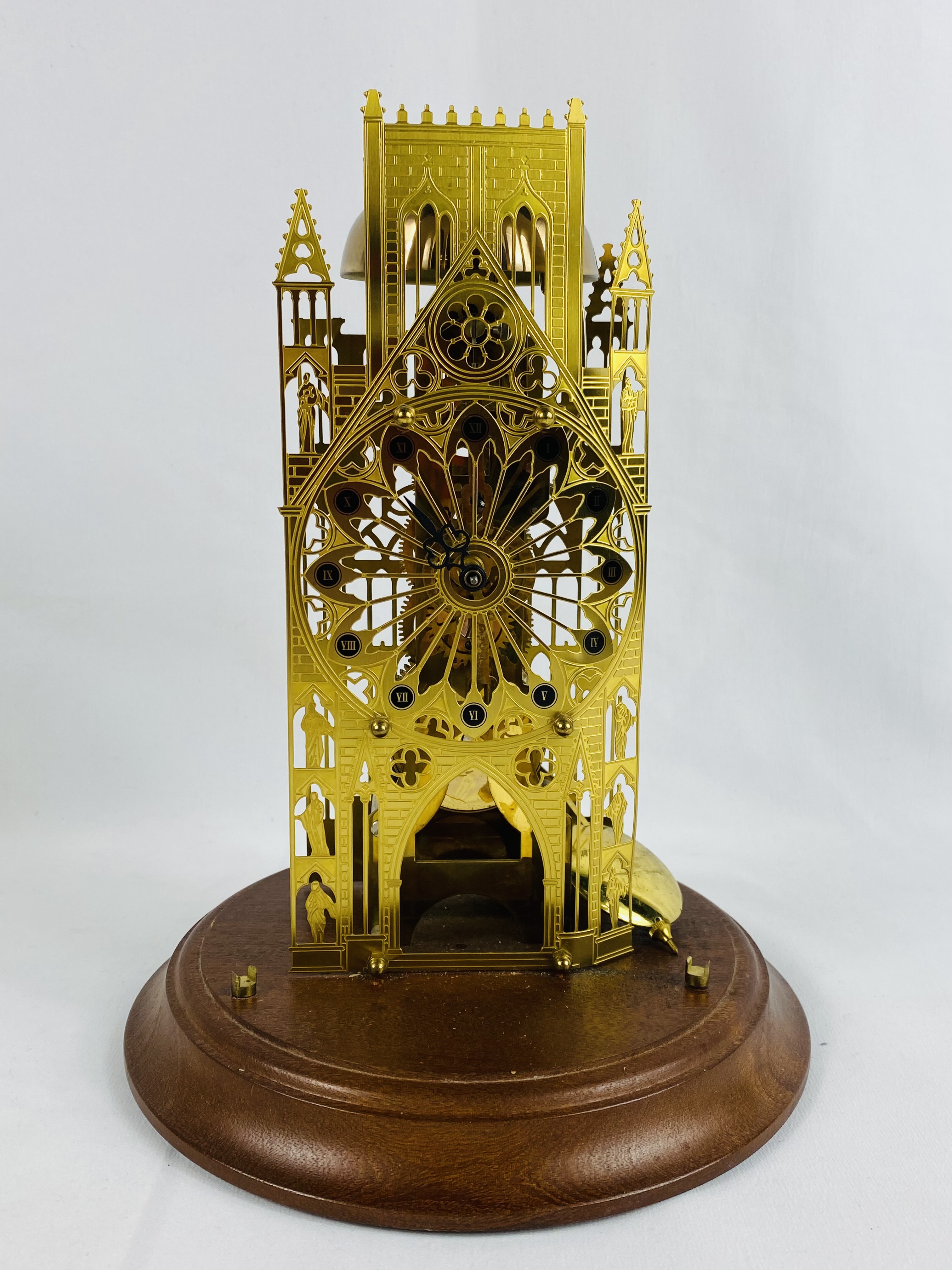 Brass skeleton clock on wood base
