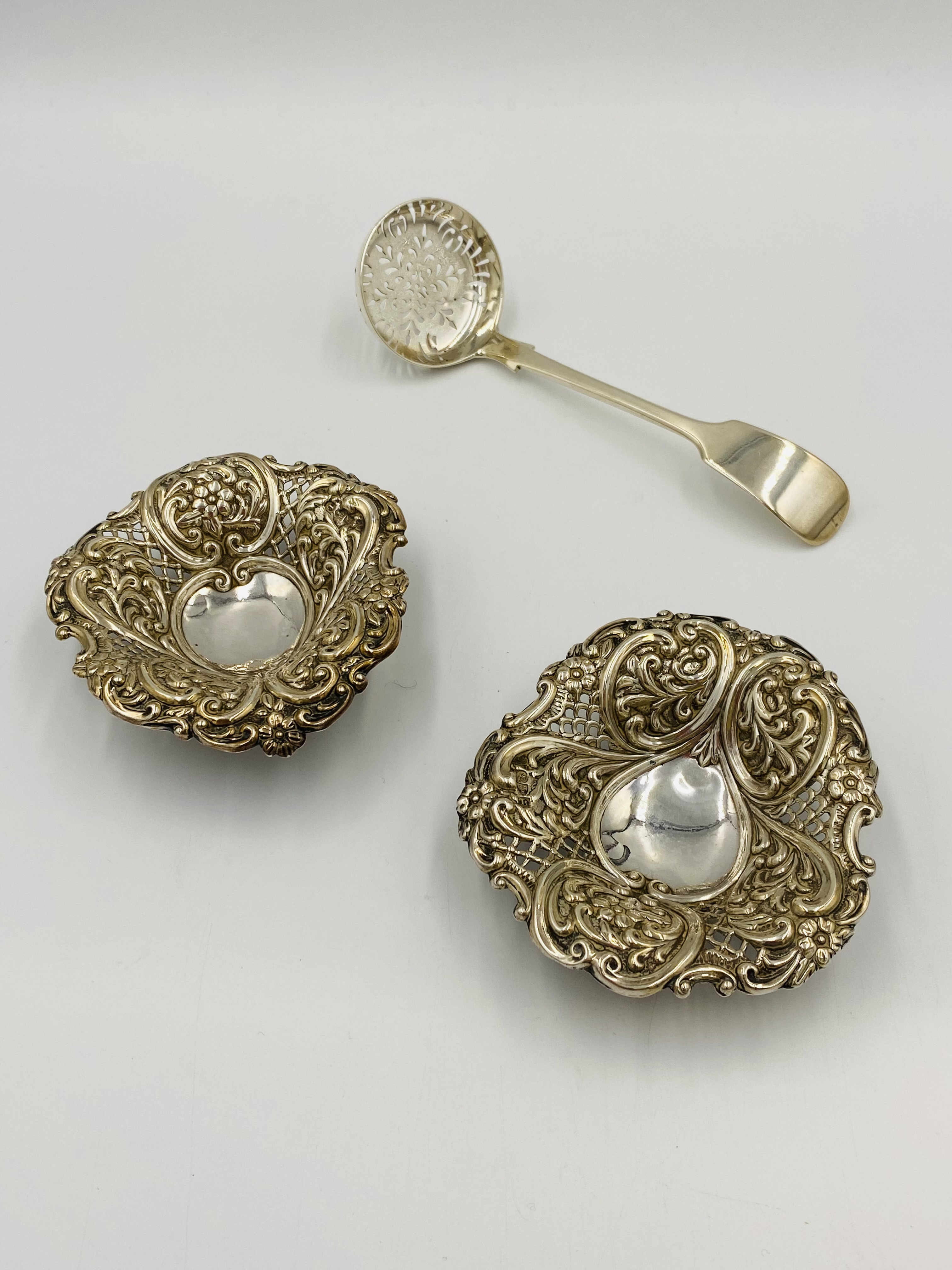 Two silver bon bon dishes and a silver sifter ladle