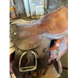 18" brown leather saddle with pair of stirrups and irons